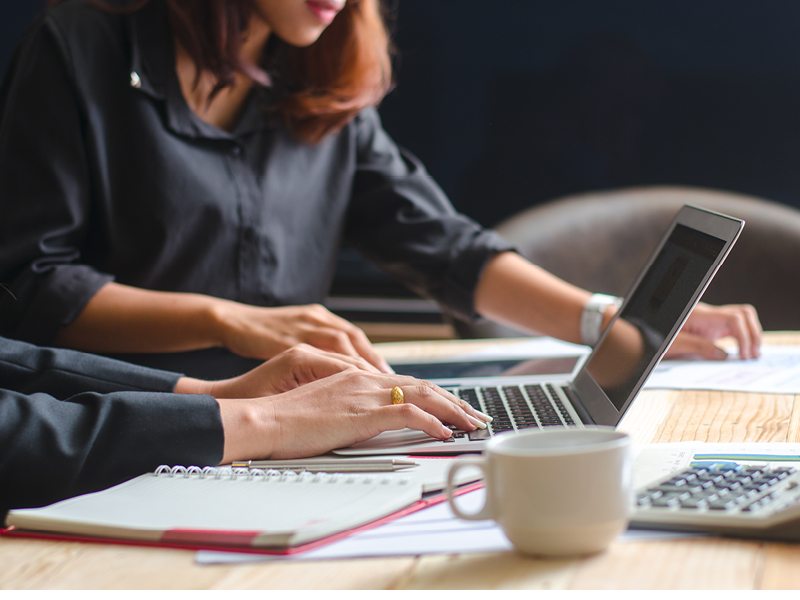 A woman and a man researching Delaware statutory trust tax reporting on their computer